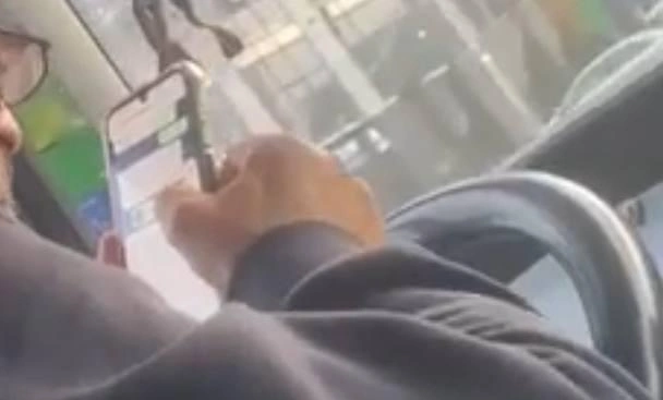 Фото: телефон в руках у водителя автобуса, кадр ТГ Ростов Главный