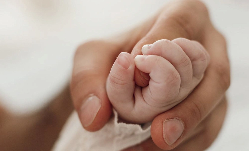 Фото: Детская ладошка во взрослой руке, кадр freepik.com