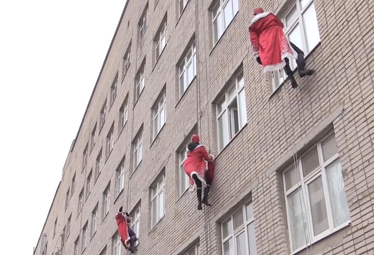 Фото:  В Ростове новогодний десант спустился с крыши областной больницы и поздравил маленьких пациентов // кадр из видео МЧС РО