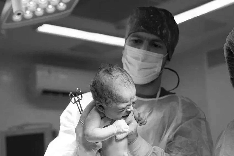 Фото: новорожденный и врач // фото: пресс-служба правительства РО